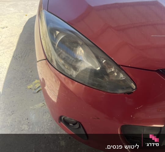 חזית רכב אדום עם פנס קדמי ופגוש